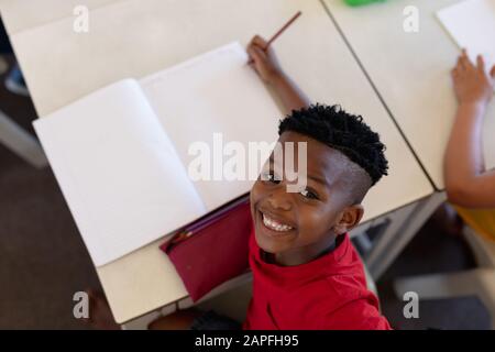 Schoolboy sitting at a desk in an elementary school classroom Stock Photo