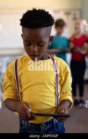 Schoolboy using a tablet computer in an elementary school classroom Stock Photo