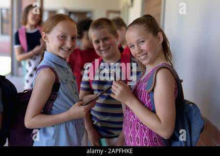 Schoolchildren standing in an outdoor corridor at elementary school Stock Photo