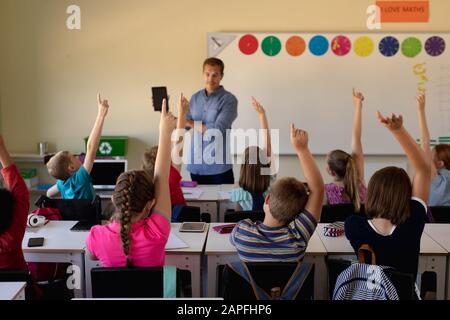 Male school teacher standing in an elementary school classroom Stock Photo
