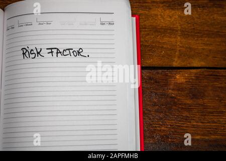 Risk factor, handwriting text on page of office agenda. Copy space. Stock Photo