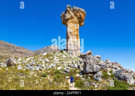 Woman looking at the rock formation Maltese Cross - a popular hiking destination in the Cederberg, South Africa Stock Photo