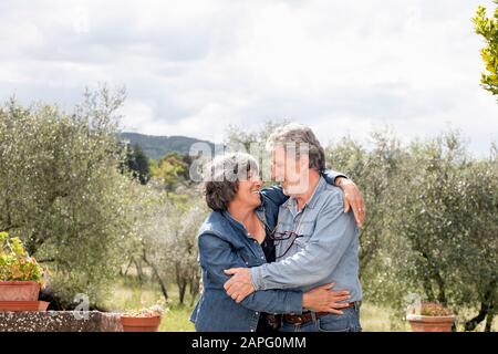 Portrait of senior couple, olive trees in background, Florence, Italy Stock Photo