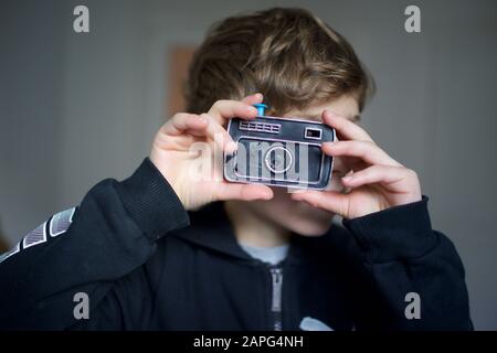Boy taking photo with a trick plastic toy, water squirting camera Stock Photo