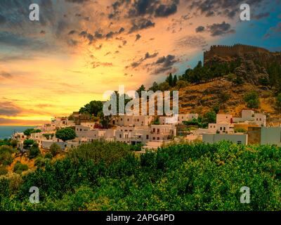 The historic city of Lindos and the Acropolis of Lindos at a beautiful sunset sky on Rhodes, Greece Stock Photo