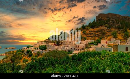 The historic city of Lindos and the Acropolis of Lindos at a beautiful sunset sky on Rhodes, Greece Stock Photo