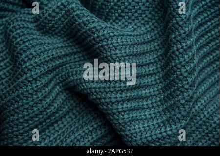 Texture of a woolen knitted green-blue sweater. Fabric turquoise background. Beautiful saturated color Stock Photo
