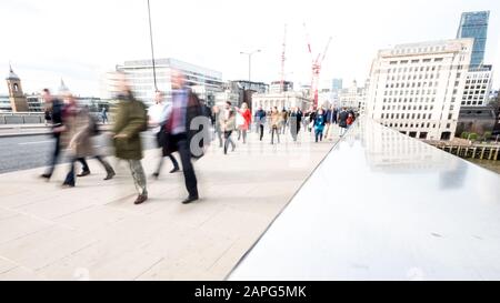 London rush hour. Commuters and office workers crossing London Bridge during their rush hour commute. Stock Photo