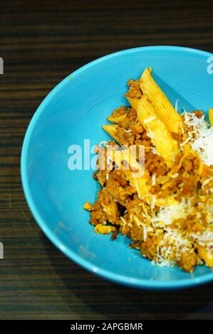 Vertical shot of macaroni and meat in a blue bowl Stock Photo