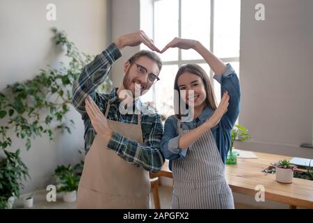 Man and woman making a heart with their hands Stock Photo