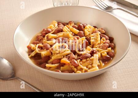 Dish of traditional Italian pasta and beans, or pasta e fagioli, , a savory soup, served at table in close up for menu advertising Stock Photo