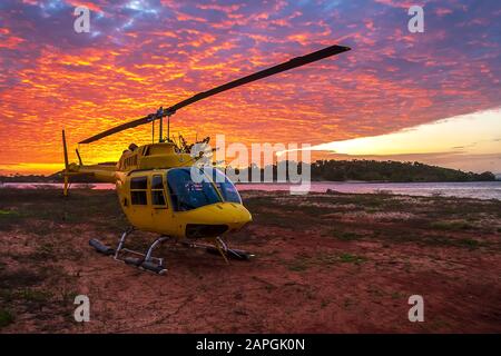 Helicopter on the land next to the sea at sunset, Australia, Northern Territory, Seisia Cape York Stock Photo