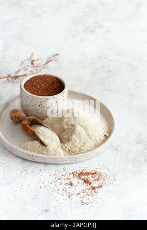 Teff flour on a plate and teff grain in a bowl close up Stock Photo