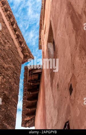Medieval wooden soffit with rafters and frieze on a house made of red terra cotta stone in Albarracin Spain Stock Photo