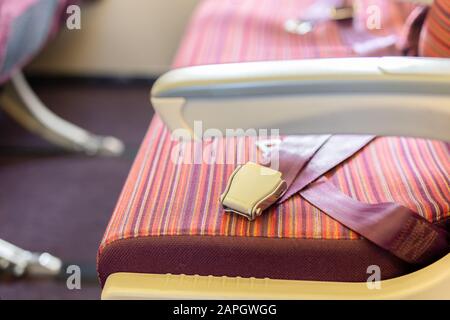 Seat belts on the passenger seat of the aircraft, Travel safety concept. Stock Photo