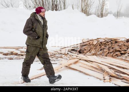 Worker in a red knitted hat is walking on the assembly site Stock Photo