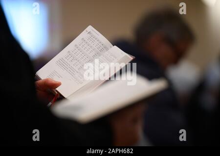 23 January 2020, Baden-Wuerttemberg, Stuttgart: During a service, believers hold an open songbook in their hands and sing. Photo: Sebastian Gollnow/dpa Stock Photo