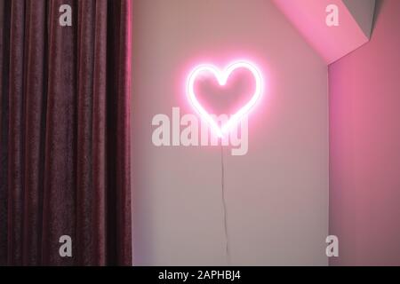 Pink Heart neon light on wall in a modern interior, retro design Valentines concept Stock Photo