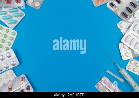 Colored pills and tablets on a blue background with copy space Stock Photo