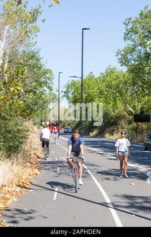 Cyclists in London cycling along Quietway 6 route on Forest Drive Stock Photo