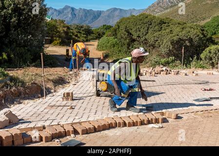 Rooiels, Western Cape, South Africa. December 2019. Workers laying a brick road in the small hamlet of Rooiels. Stock Photo