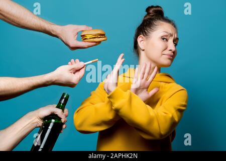 girl in bright clothes refuses junk food, alcohol and cigarettes, preferring a healthy lifestyle Stock Photo