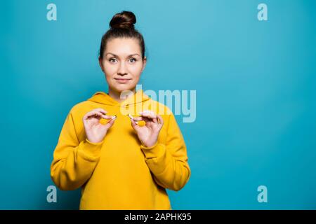 girl in a sweatshirt holds a broken cigarette and smiles, Copy space Stock Photo