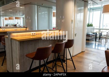 boarding area at munich airport terminal 2 with chairs and power plugins . Stock Photo