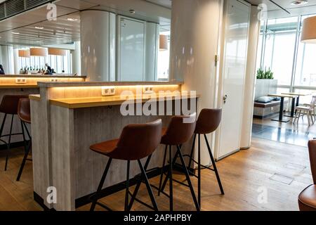 boarding area at munich airport terminal 2 with chairs and power plugins . Stock Photo