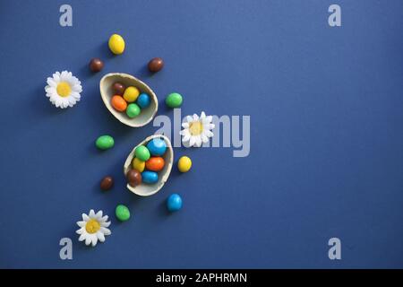 , Chocolate Easter Eggs with colorful candies over classic dark blue background, easter concept Stock Photo