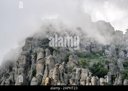 The Valley of Ghosts on Demerdji mountain with low lying clouds, Crimea, Russia. This place is a natural landmark of Crimea. Beautiful view of fancy m Stock Photo
