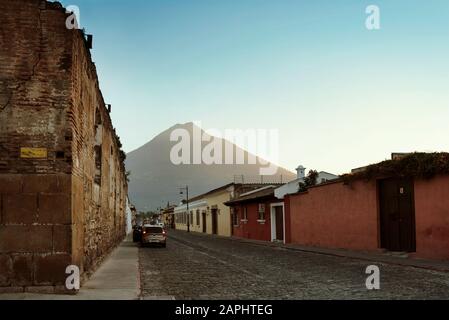 Scenic street view with Volcan de Agua in the background. Avenida Norte and Calle de los Carros corner, Antigua, Guatemala. Jan 2019