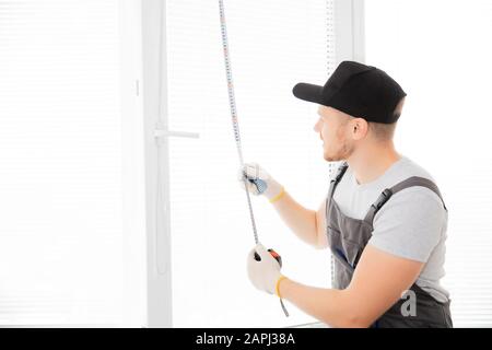 Master worker measures upvc window with ruler, installation process. Stock Photo