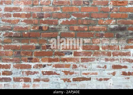 an old white washed red brick wall in an alley Stock Photo