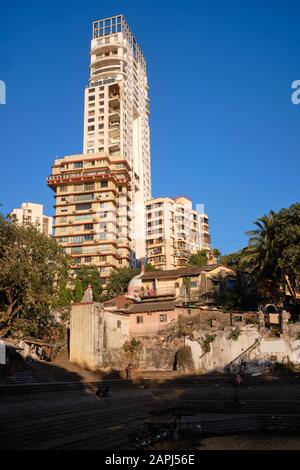 High rise apartment buildings are towering over a Hindu temple at holy Hindu site Banganga Tank, in prosperous Walkeshwar area, Mumbai, India Stock Photo