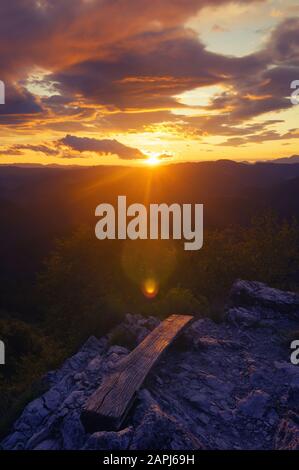 Beautiful sunset and colorful clouds over landscape from top of the hill. Hiking, self-reflection, colors in nature, optimism and weather concepts. Stock Photo