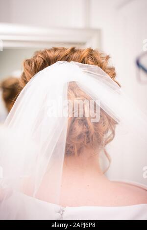 White bridal veil in done up bride's hair before ceremony Stock Photo