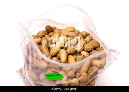 Plastic zip-lock bag filled with unshelled peanuts, isolated on white background Stock Photo