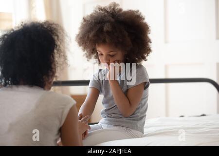 African mother holds hand of little daughter talks gives support Stock Photo