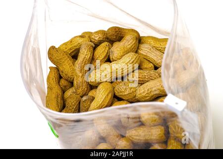 Plastic zip-lock bag filled with unshelled peanuts, isolated on white background Stock Photo