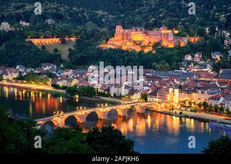 The city of Heidelberg, Germany, with its famous landmarks, the illuminated historic castle and the Old Bridge on Neckar river, shot at dusk Stock Photo