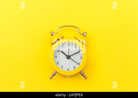 Ringing twin bell vintage classic alarm clock Isolated on yellow colourful trendy modern background. Rest hours time of life good morning night wake up awake concept. Flat lay top view copy space Stock Photo