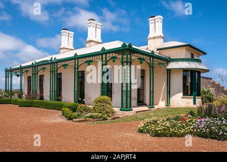 Stanley, Tasmania, Australia - December 15, 2009: Hightfield Historic Site. Closeup of White with green trim main house with tall chimneys with flower Stock Photo