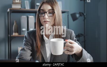 Woman having coffee while working Stock Photo