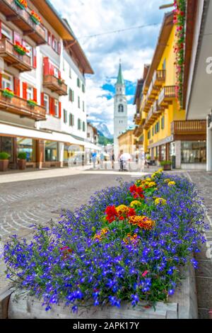 Flowers on famous resort Cortina D'Ampezzo main street in Dolomites mountain range, Italy Stock Photo