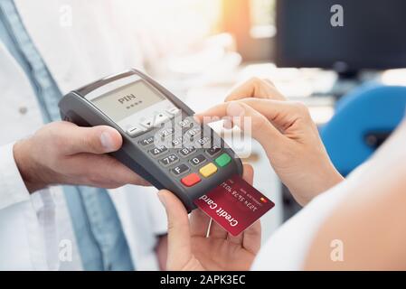 Payment by credit card with terminal. Woman enters the pin code Stock Photo
