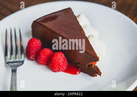 Delicious slice of chocolate mouse cake with raspberries and whipped cream Stock Photo