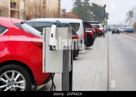 Electric vehicle charger station installed in parking lot in residential complex. Eco friendly transport concept. Stock Photo