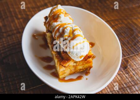 Bread pudding dessert sitting on a wooden table. Stock Photo