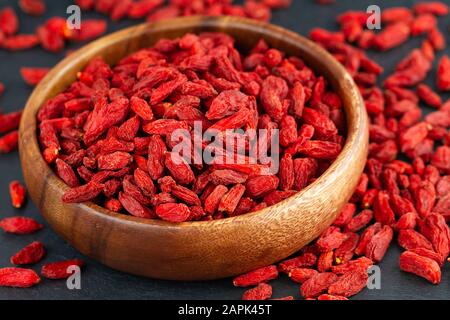 Goji berries in wooden cup. View from above, selective focus Stock Photo